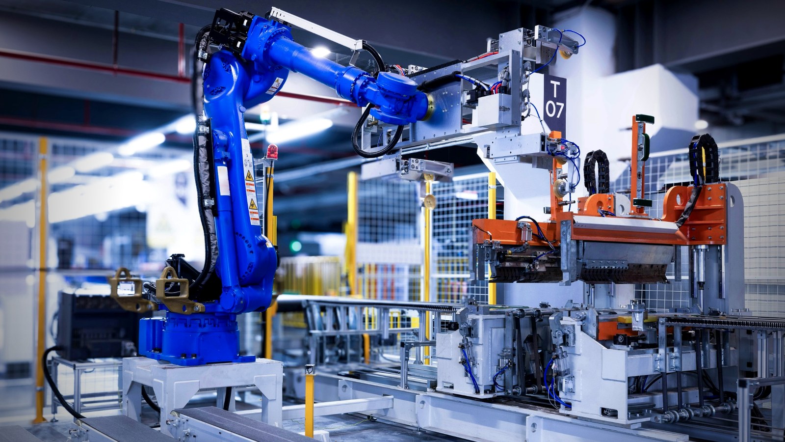 Modern production cell with robotic arm and conveyors, representing predictive maintenance insights.